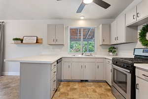 Kitchen featuring gray cabinets, sink, ceiling fan, kitchen peninsula, and stainless steel appliances