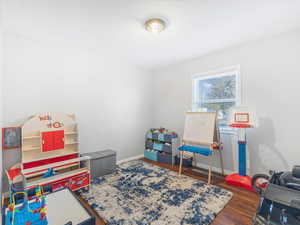 Recreation room with dark hardwood / wood-style floors