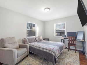 Bedroom with dark hardwood / wood-style flooring