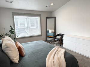 Bedroom featuring carpet flooring and a textured ceiling