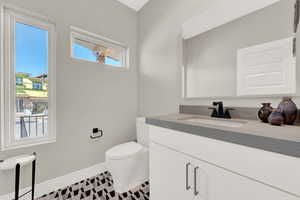 Bathroom featuring tile patterned floors, vanity, and toilet