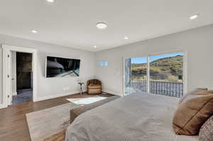 Bedroom featuring access to outside, connected bathroom, and hardwood / wood-style flooring