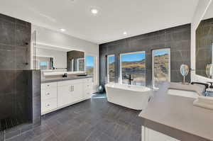 Bathroom with vanity, tile walls, and shower with separate bathtub