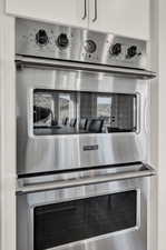 Details featuring white cabinetry and double oven