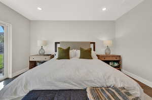 Bedroom featuring access to exterior and dark wood-type flooring