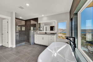 Bathroom featuring separate shower and tub and vanity