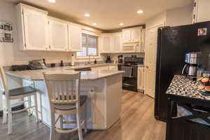 Kitchen featuring kitchen peninsula and light wood-style floors