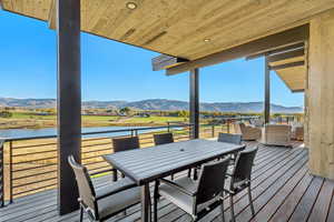 Wooden terrace featuring a rural view and a water and mountain view