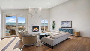 Living room featuring a mountain view, hardwood / wood-style floors, high vaulted ceiling, and a premium fireplace