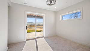 Empty room with a mountain view and light colored carpet