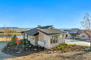 View of side of property with a water and mountain view