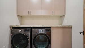 Laundry area featuring washer and dryer and cabinets