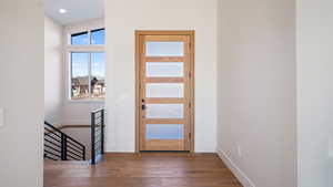 Entrance foyer featuring hardwood / wood-style floors and lofted ceiling