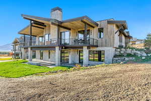 Back of property with a balcony and a patio