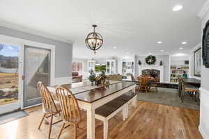 Dining room featuring plenty of natural light, fireplace, light hardwood / wood-style floors, and ornamental molding