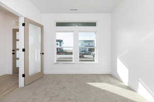 Unfurnished room featuring light colored carpet