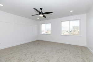 Empty room featuring ceiling fan and light colored carpet