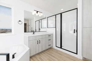 Bathroom featuring vanity, shower with separate bathtub, and hardwood / wood-style flooring