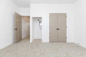 ADU Unfurnished bedroom with light carpet, laundry hook-ups, and a closet