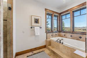 Bathroom with tile patterned floors and a relaxing tiled tub