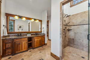 Bathroom featuring a wealth of natural light, vanity, and an enclosed shower