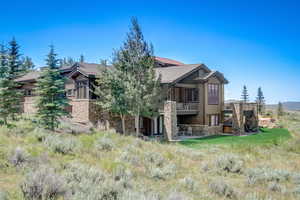 Rear view of house with a balcony and a patio