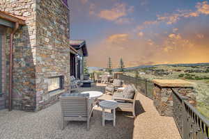 Patio terrace at dusk with an outdoor living space with a fireplace