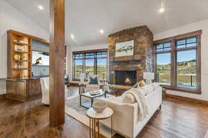 Living room with dark hardwood / wood-style floors, a fireplace, and high vaulted ceiling