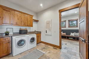 Clothes washing area featuring cabinets, independent washer and dryer, and sink