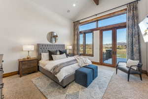 Carpeted bedroom featuring access to outside, french doors, and high vaulted ceiling