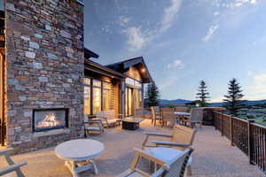 View of patio featuring an outdoor stone fireplace and a mountain view