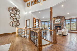 Corridor featuring high vaulted ceiling, wood-type flooring, and a wealth of natural light