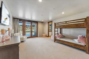 Carpeted bedroom featuring access to exterior and french doors