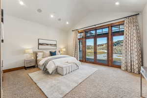 Bedroom featuring french doors, access to outside, high vaulted ceiling, and light colored carpet