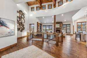 Corridor featuring beamed ceiling, dark wood-type flooring, and high vaulted ceiling