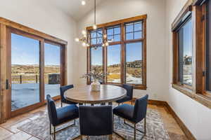 Dining room featuring a notable chandelier and vaulted ceiling