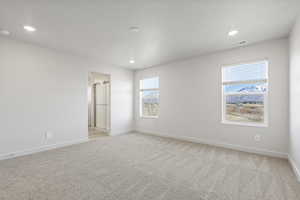 Empty room with a wealth of natural light and light carpet