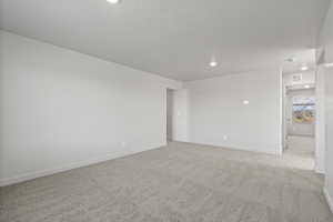 Carpeted empty room with a textured ceiling