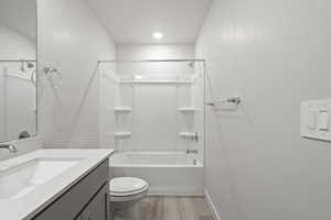 Full bathroom with bathtub / shower combination, vanity, toilet, and wood-type flooring