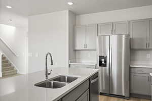 Kitchen featuring sink, gray cabinets, light hardwood / wood-style floors, and appliances with stainless steel finishes