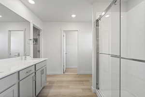 Bathroom featuring vanity, an enclosed shower, and hardwood / wood-style flooring