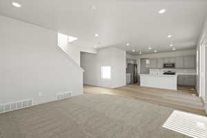 Unfurnished living room featuring light hardwood / wood-style floors and sink