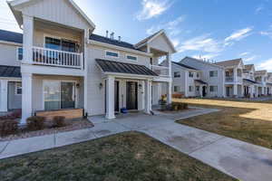 Townhome / multi-family property featuring a front yard and a balcony