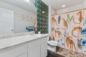 Bathroom featuring walk in shower, vanity, wood-type flooring, and toilet