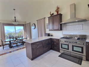 Kitchen featuring lofted ceilings, a wealth of natural light, over-sized fridge/freezer and professional range with dual ovens.