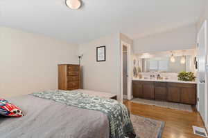 Bedroom featuring ensuite bath and light wood-type flooring