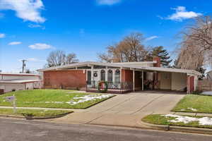 Ranch-style home with a front yard and a carport