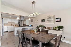 Dining area featuring lofted ceiling and sink