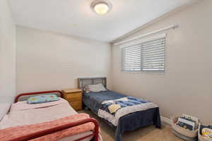 Bedroom featuring carpet floors and vaulted ceiling