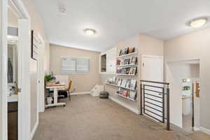 Carpeted home office featuring vaulted ceiling